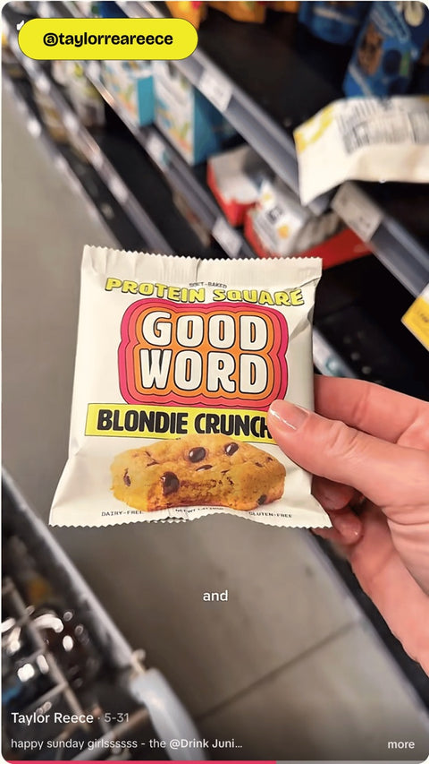 Customer holding a Good Word Blondie Crunch Protein Square at Whole Foods