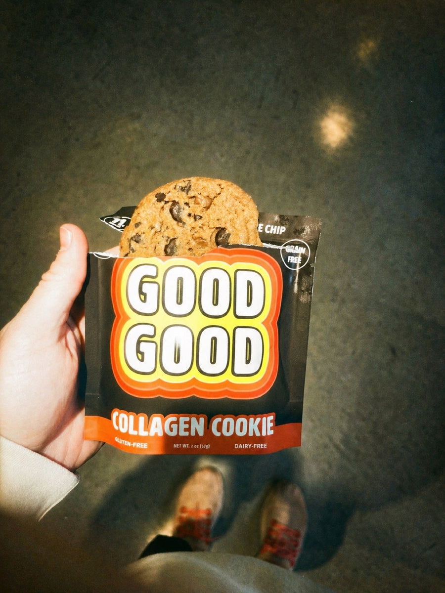 Hand holding a GOOD GOOD Collagen Cookie chocolate chip in its retro orange-and-yellow grain-free, gluten-free, dairy-free package