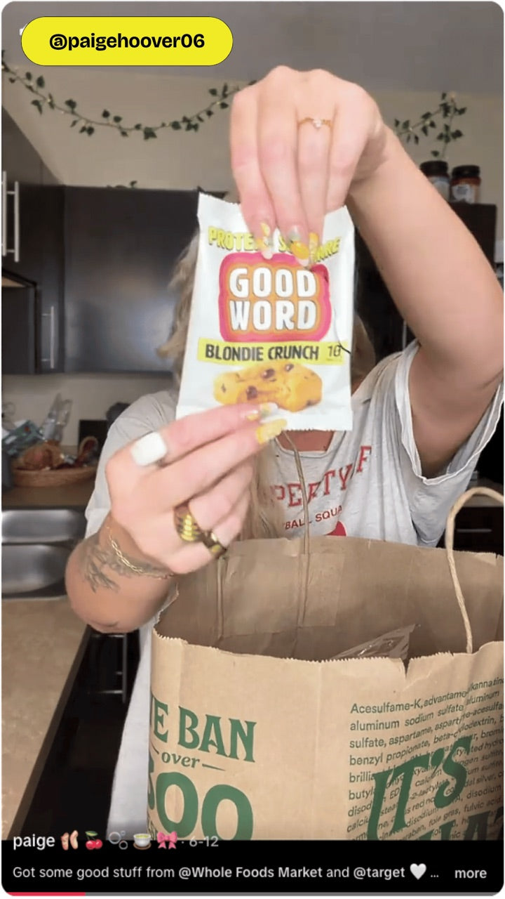 Customer holding a Good Word Blondie Crunch Protein Square after shopping